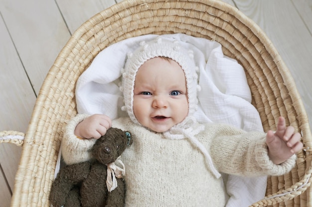 Baby in Korbwiege mit Holzspielzeug Muttertag Kinderschutztag Fröhliches Kind glückliche Kindheit