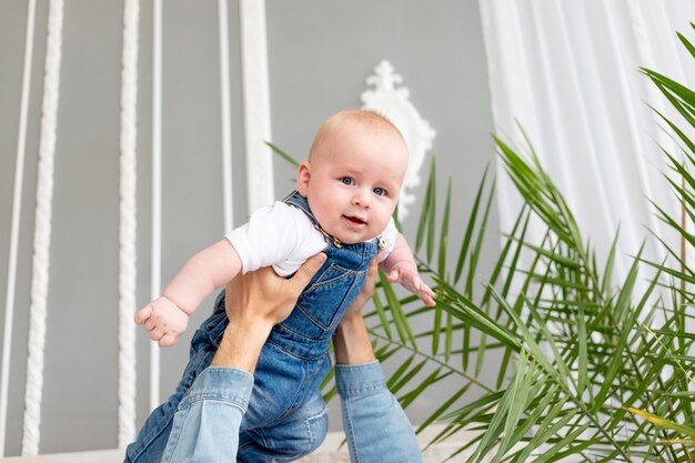 Baby in Papas Armen, das Flugzeug spielt, glückliche Kindheit