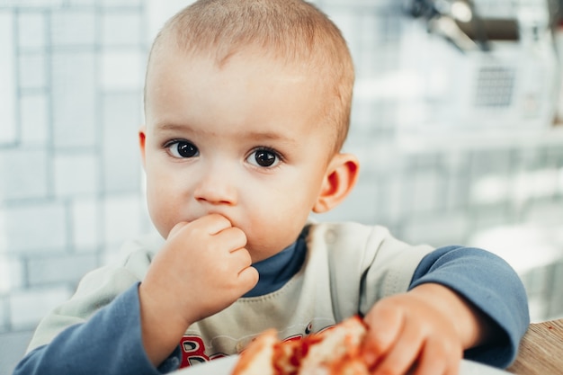 Baby isst einen Granatapfel, reif und saftig, sehr lecker und freudig