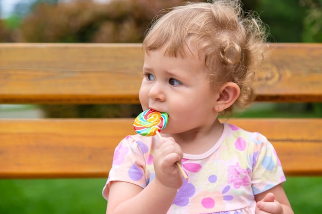 Baby isst einen Lutscher im Park Selektiver Fokus