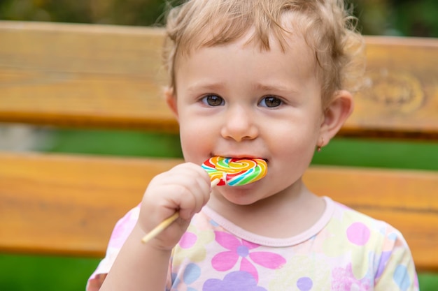 Baby isst einen Lutscher im Park Selektiver Fokus