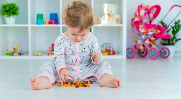 Baby isst Geleebonbons zu Hause Selektiver Fokus Kind