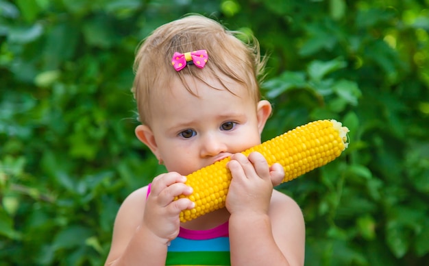 Baby isst Mais mit seinen Händen. Selektiver Fokus.