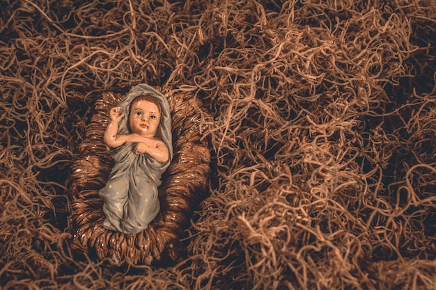 Baby Jesus, das in eine Krippe Weihnachtshintergrund legt