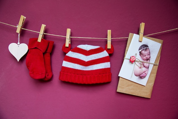 Baby Kinderkleidung Hut und Socken und Grußkarte mit Neugeborenen hängen an der Wäscheleine