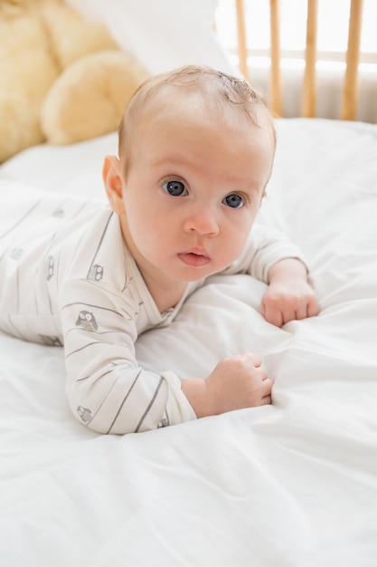 Baby liegt auf Babybett