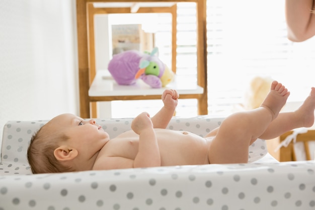 Baby liegt auf Babybett