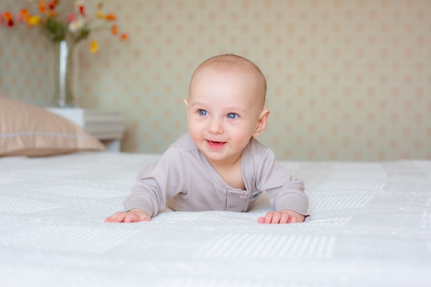 Baby liegt auf dem Bauch im Schlafzimmer auf dem Bett