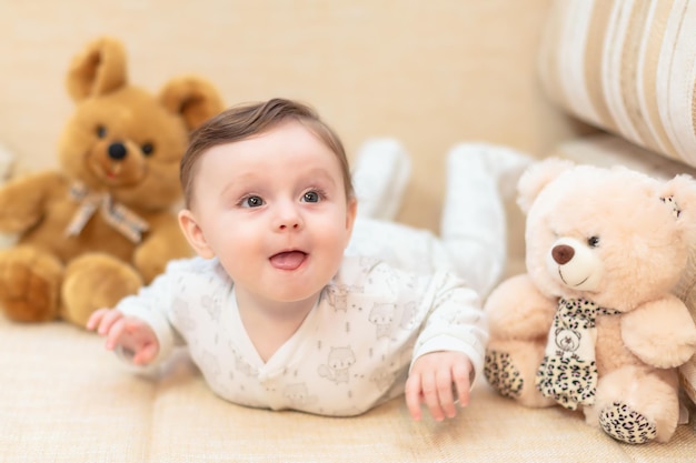 Baby liegt auf der Couch zwischen den Spielsachen