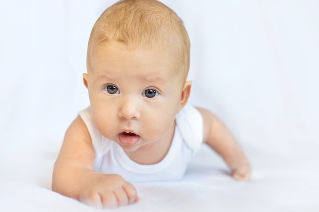 Baby liegt auf ihrem Bauch auf einem weißen Hintergrund.