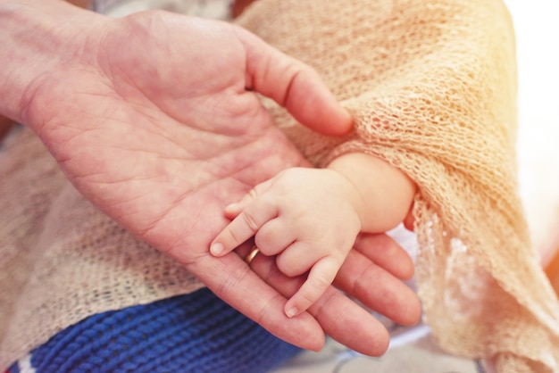 Baby macht ein Handzeichen auf der Palme seines Vaters