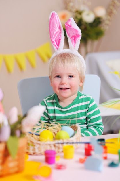 Baby malt Ostereier in der gelben Farbe