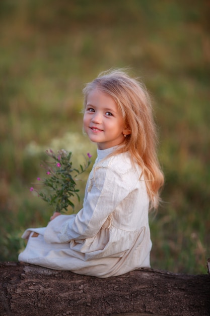 Baby mit einem Blumenstrauß von wilden Blumen