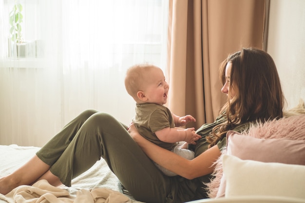 Baby mit Mutter auf dem Bett