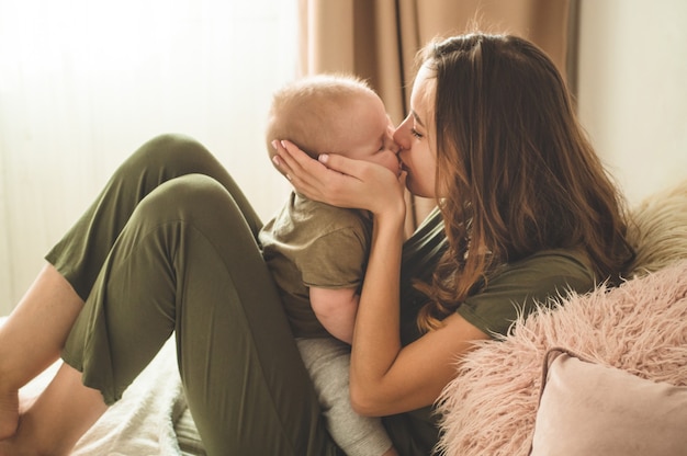 Baby mit Mutter auf dem Bett