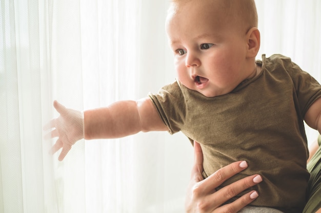 Baby mit Mutter nahe dem Fenster