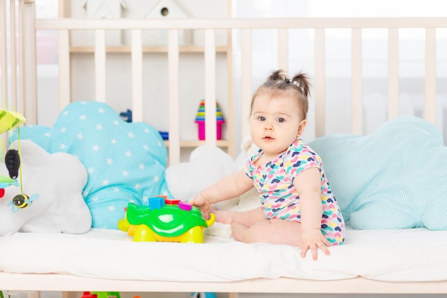 Baby mit Spielzeug in der Krippe zu Hause Spielzeug für Kleinkinder Frühe Entwicklung