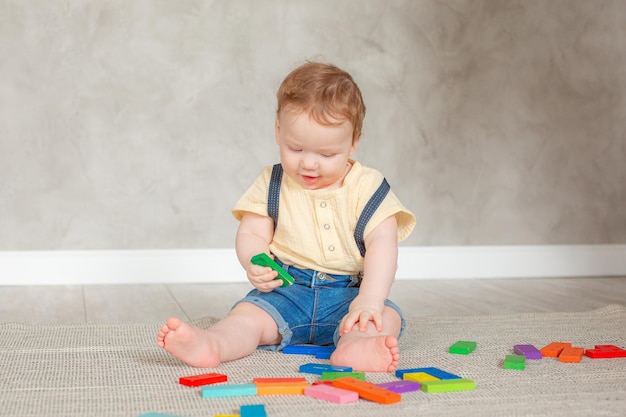 Baby mit Spielzeug krabbelt zu Hause auf dem Boden