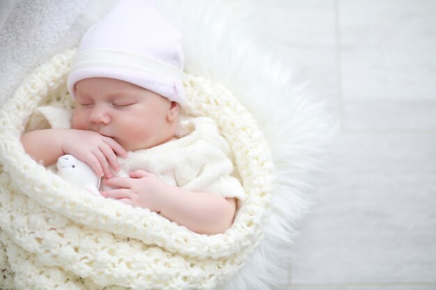 Baby Neugeborenes schlafend in eine warme Decke gehüllt