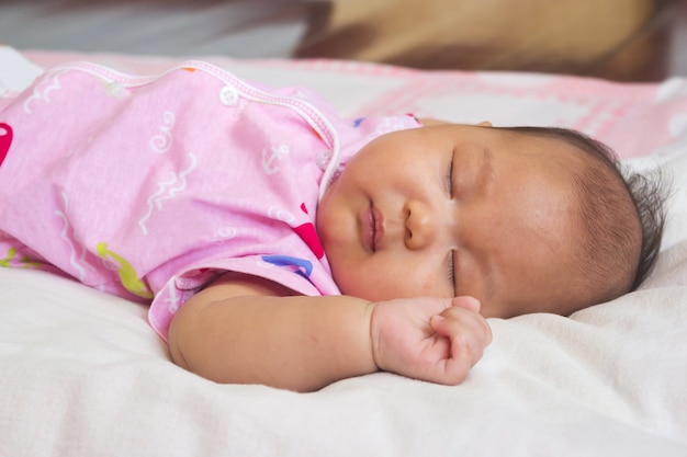 Baby schläft auf dem Bett.