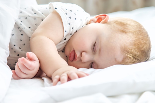 Baby schläft auf einem weißen Bett