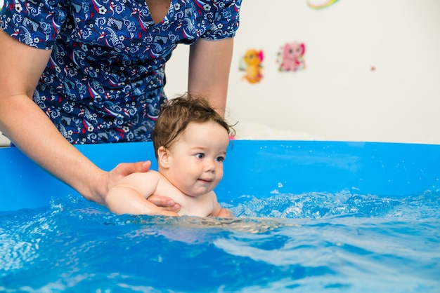 Foto baby schwimmen im pool mit einem gesundheitscoach, wasserbehandlungen für das kind