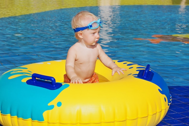 Baby schwimmen mit Spaß im Wasserparkpool mit aufblasbarem Spielzeug.