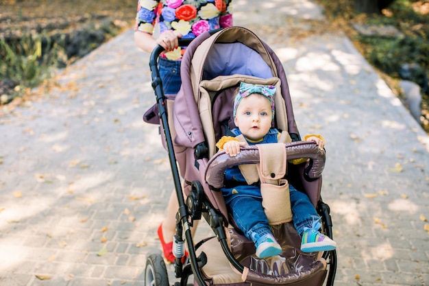 Baby sitzt alleine auf der Kutsche. Baby im sitzenden Kinderwagen auf Natur