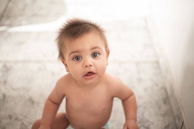 Baby sitzt auf dem Boden zu Hause