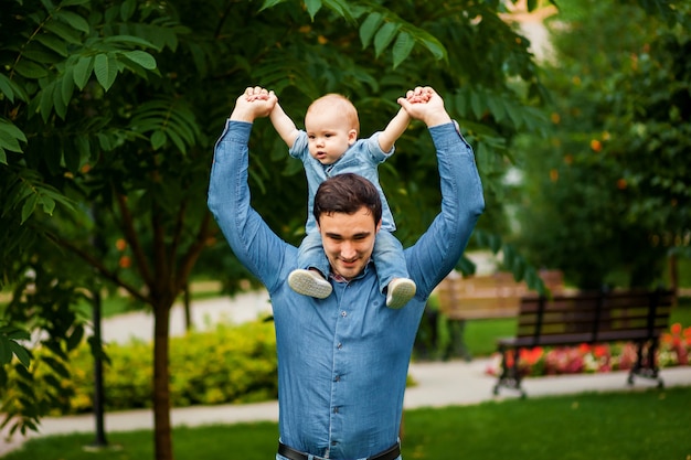 Baby sitzt auf dem Hals des Vaters