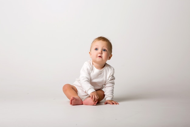 Baby sitzt auf einem hellen Hintergrund