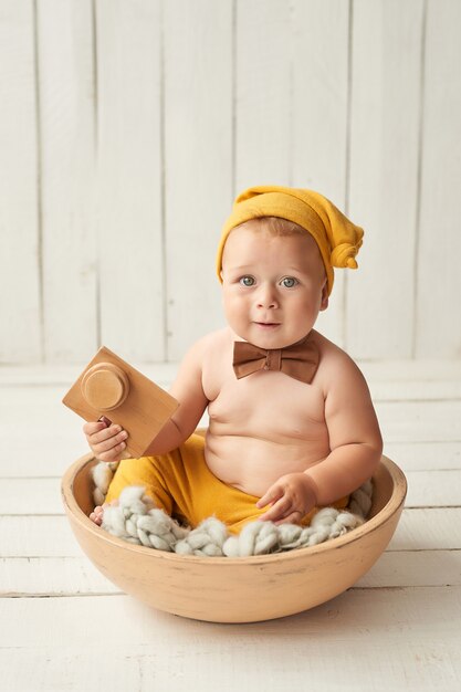 Baby sitzt auf Krippe. Kinderschutztag. Glückliche Kindheit.