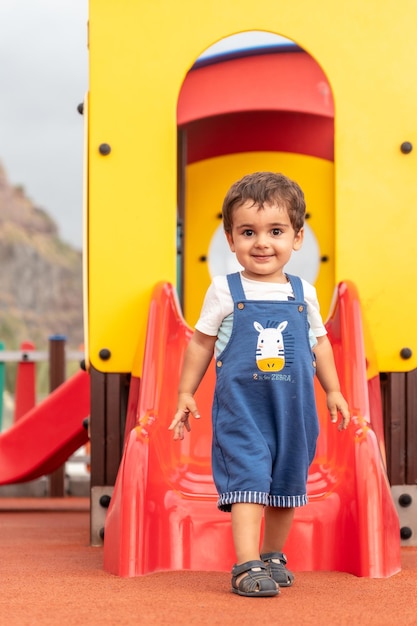 Baby spielt auf einem Spielplatz und hat Spaß im Sommerpark für kleine Kinder