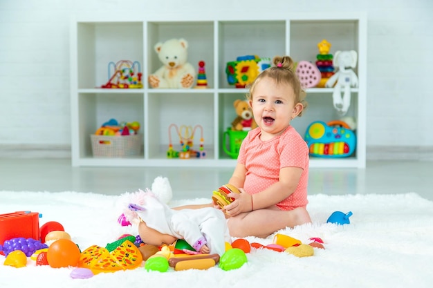 Baby spielt mit Spielzeug in ihrem Zimmer Selektiver Fokus Kind