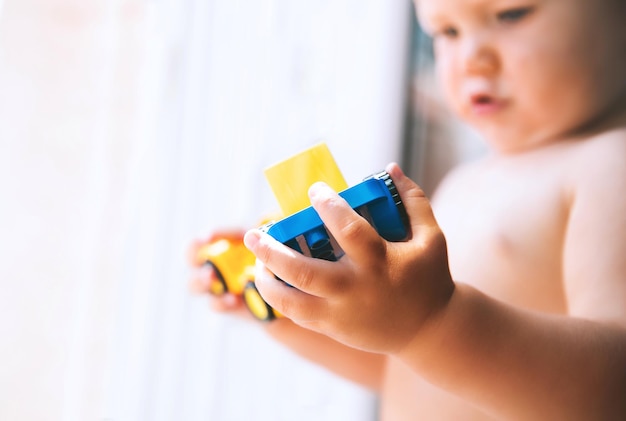 Baby spielt und entdeckt mit buntem Spielzeug zu Hause Kleinkind spielt mit Bauklötzen und Konstrukteuren