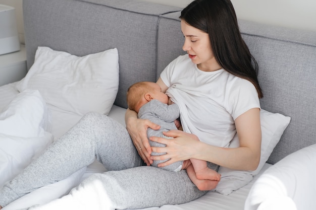 Baby stillen und auf Mutters Händen schlafen