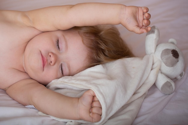 Baby wacht im Bett auf, gesunde Kinder schlafen