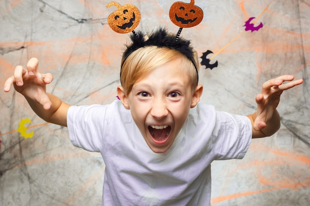 Baby zeigt lustige Gesichter für die Kamera an Halloween