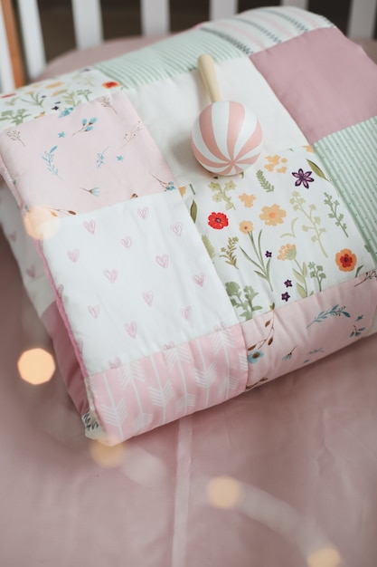 Babybett mit rosa Patchworkdecke und Textil für Kinderzimmer