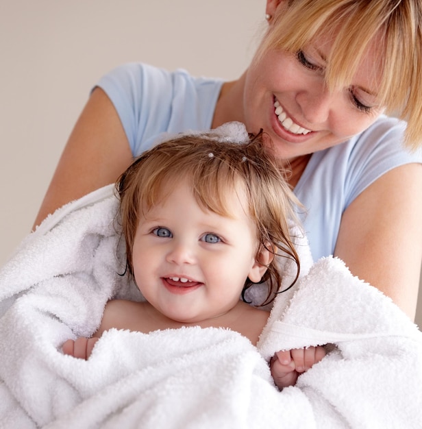 Babyblaue Augen Schnappschuss einer Mutter, die ihr frisch gewaschenes Baby in einem Handtuch trägt