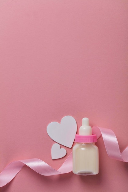 Babyflasche auf pastellrosa Hintergrund Neue Babyankunft
