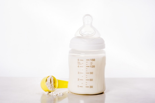 Babyflasche und Milch auf Weiß