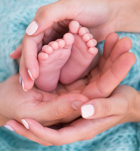 Babyfüße in den Händen der Eltern