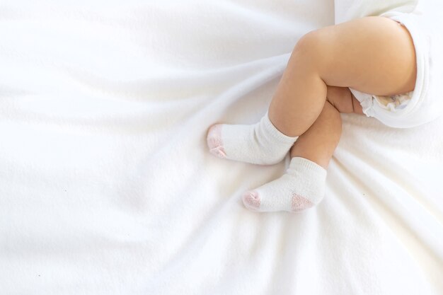 Babyfüße in den Socken gegen weißen Hintergrund.