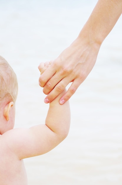 Babyhand mit Mutterfinger isoliert auf weiß