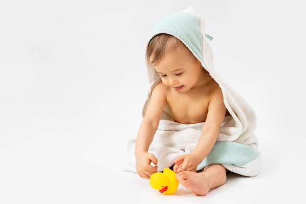 Babyhygiene und Pflege. Netter Säuglingsjunge nach dem Baden in Kapuzenhandtuch gewickelt.