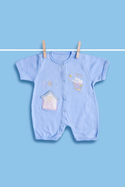 Babykleidung auf der Wäscheleine auf blauem Hintergrund