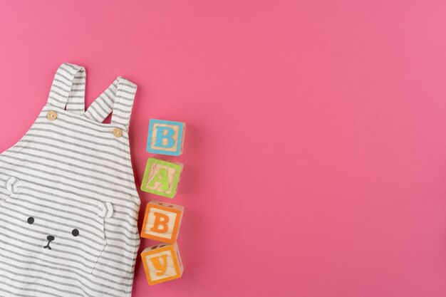 Foto babykleidung auf rosa hintergrund draufsicht