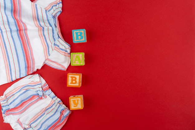 Babykleidung Draufsicht auf rote Oberfläche