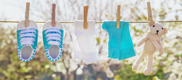 Babykleidung und Accessoires wiegen das Seil nach dem Waschen im Freien.